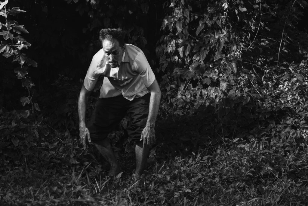 Shinichi in the woods, stooped.